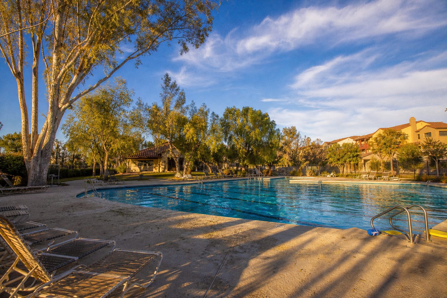 Community swimming pool at an Old Orchard HOA in Valencia with residential homes visible in the background.