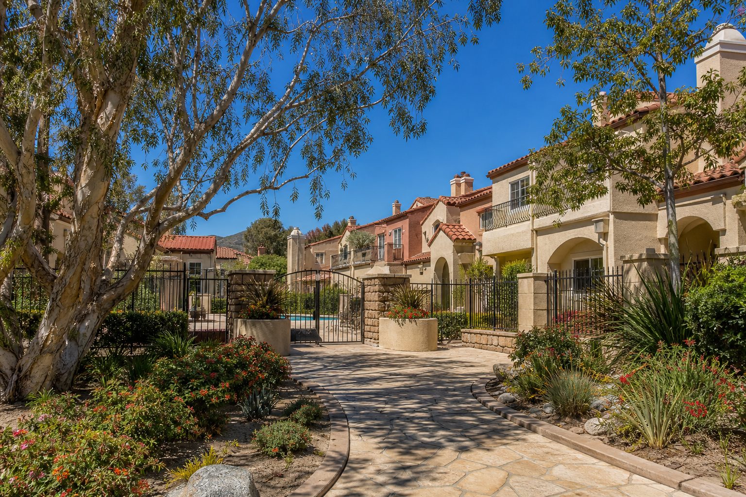 Established 1980s-built townhome community with Mediterranean-style architecture and mature landscaping in Saugus.